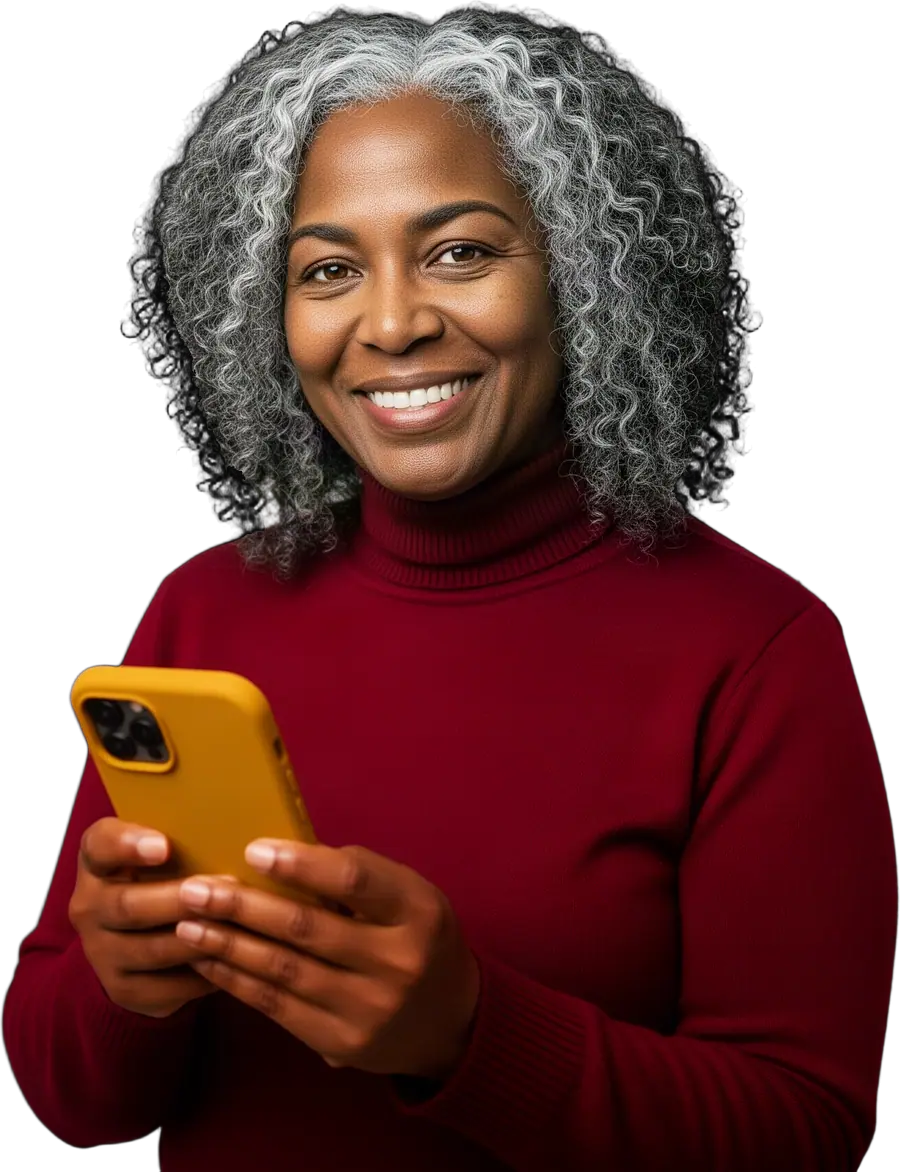 Smiling woman with curly grey hair in a burgundy turtleneck holding a mustard-yellow smartphone in both hands