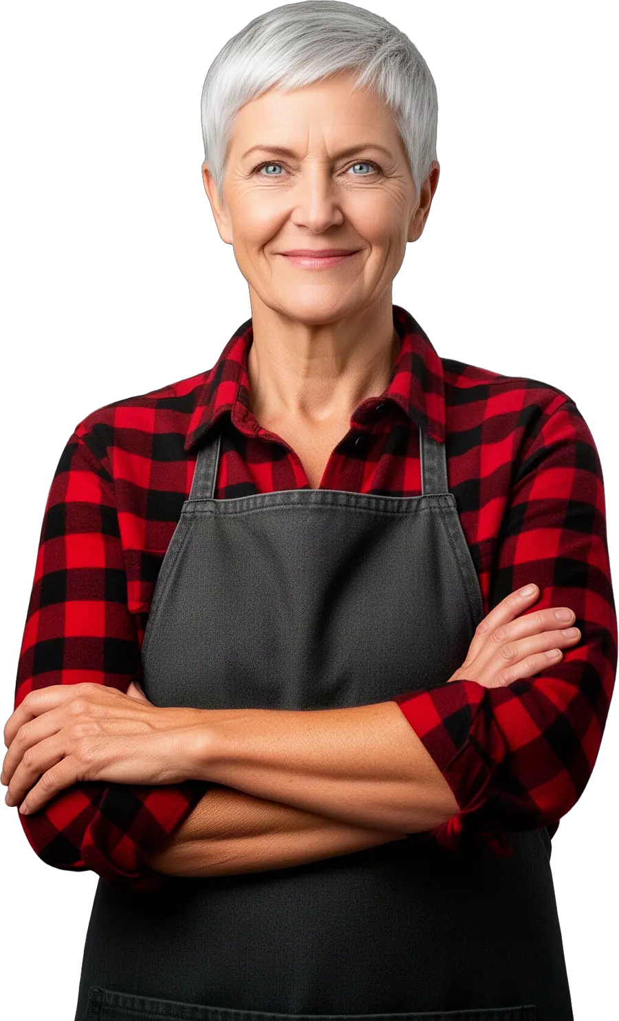 Smiling woman with short silver hair in a red buffalo-check shirt and grey apron with arms crossed